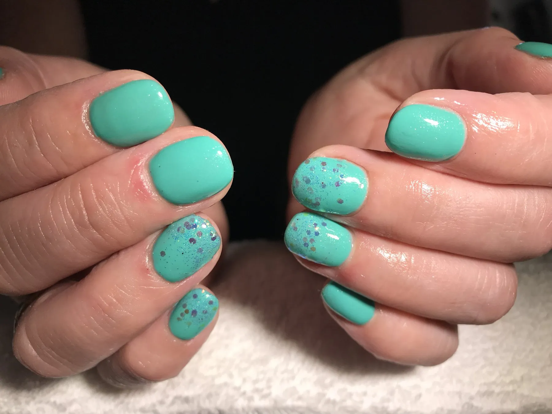 Turquoise nagels met gespikkelde accentnagels